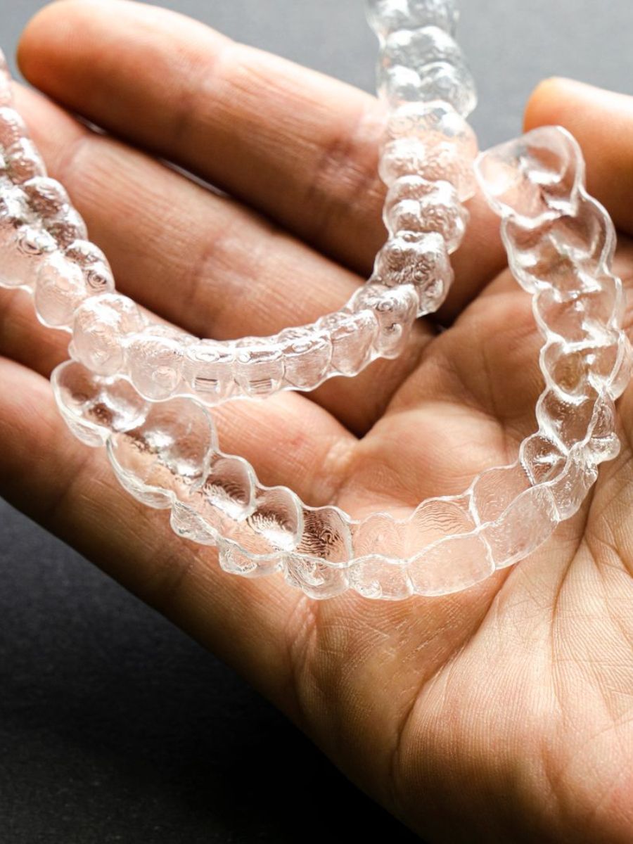 Set of orthodontic retainers held in a hand
